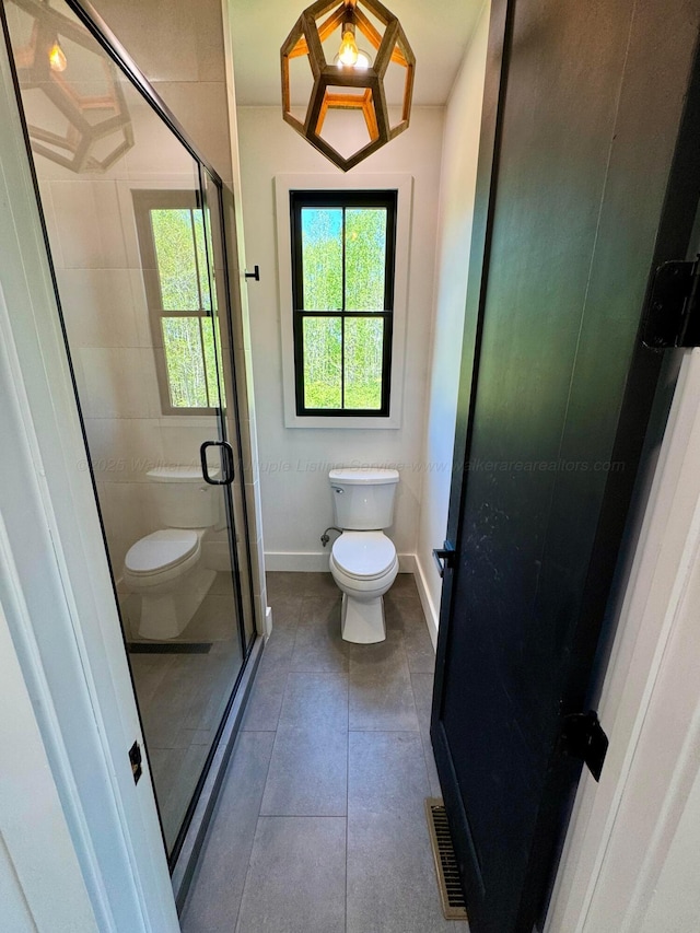 full bath with visible vents, toilet, a stall shower, and tile patterned floors
