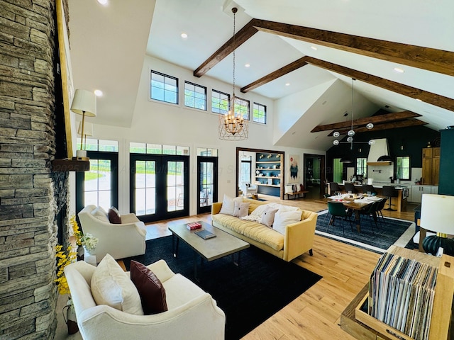 living area with recessed lighting, wood finished floors, beam ceiling, high vaulted ceiling, and a notable chandelier