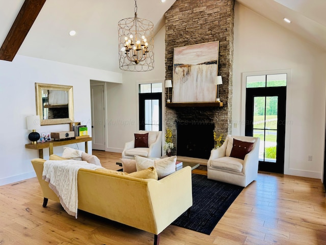 living room with high vaulted ceiling, an inviting chandelier, light wood finished floors, and baseboards