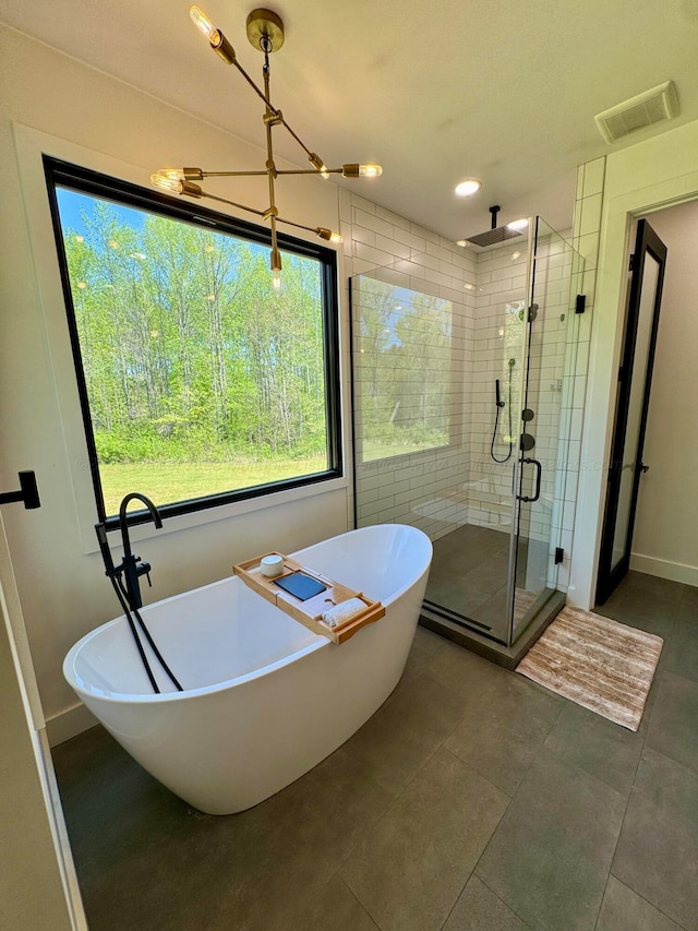 bathroom with tile patterned flooring, visible vents, baseboards, a soaking tub, and a stall shower