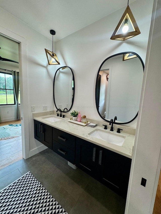 bathroom with double vanity, baseboards, and a sink