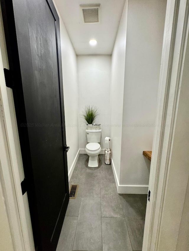 bathroom featuring baseboards, visible vents, and toilet