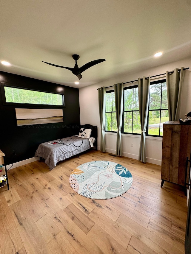 bedroom featuring wood-type flooring, baseboards, multiple windows, and recessed lighting