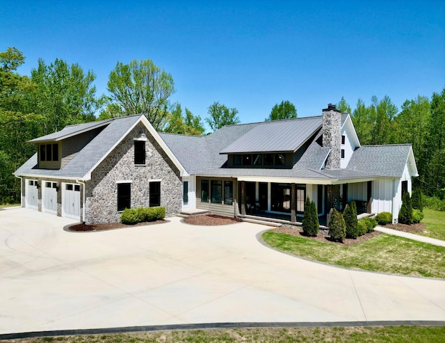 view of front facade featuring stone siding, driveway, a chimney, and a garage
