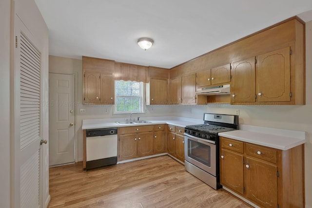 kitchen with ventilation hood, stainless steel gas stove, dishwasher, a sink, and light wood-type flooring