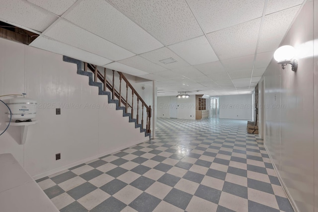 finished basement featuring stairway, a drop ceiling, baseboards, and tile patterned floors