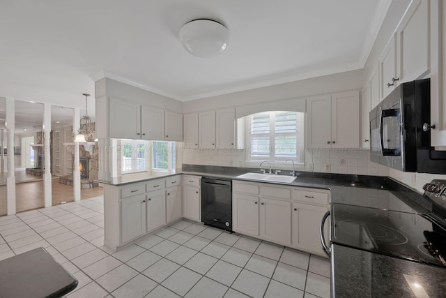 kitchen with tasteful backsplash, a sink, black appliances, a peninsula, and white cabinetry