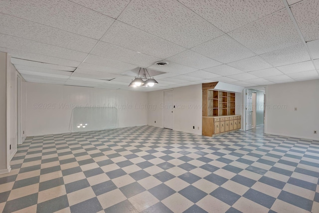 below grade area with a paneled ceiling and visible vents
