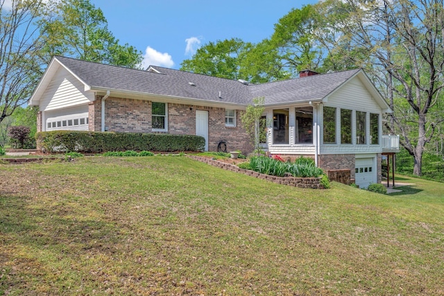 single story home with a front lawn, a shingled roof, a garage, brick siding, and a sunroom