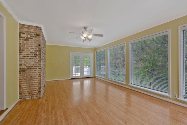 spare room with crown molding, ceiling fan, french doors, light wood finished floors, and baseboards