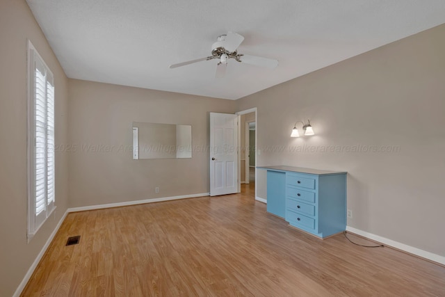 unfurnished bedroom with baseboards, visible vents, light wood-style floors, and ceiling fan