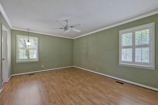 empty room featuring a textured ceiling, plenty of natural light, visible vents, and light wood-style flooring