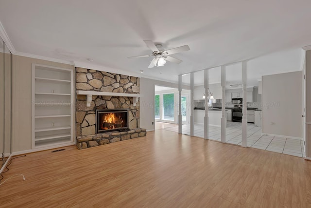 unfurnished living room with visible vents, ornamental molding, light wood-style floors, a fireplace, and ceiling fan
