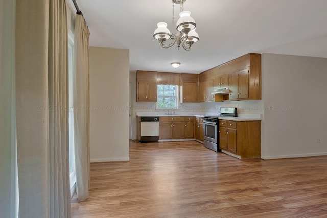 kitchen featuring under cabinet range hood, light countertops, white dishwasher, stainless steel range with gas cooktop, and a chandelier