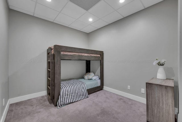 carpeted bedroom with a drop ceiling and baseboards