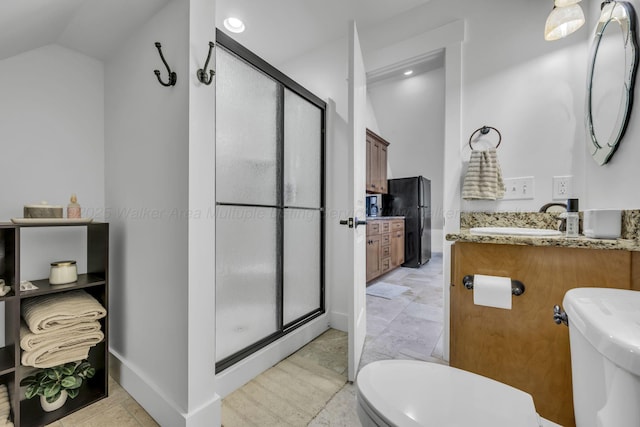 full bathroom featuring toilet, vanity, a shower stall, lofted ceiling, and baseboards