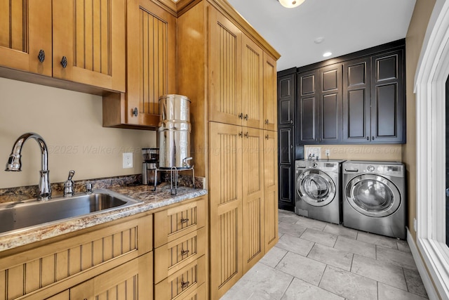 clothes washing area with light tile patterned flooring, washing machine and dryer, cabinet space, and a sink