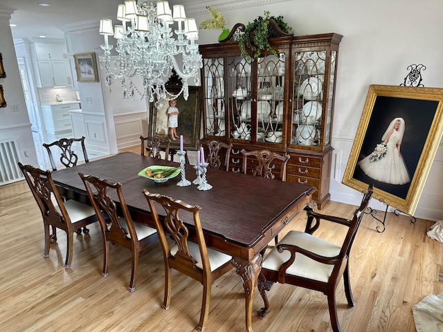 4963 Littleville Rd, Haleyville, AL 35565 - dining space with light wood-type flooring, a decorative wall, a chandelier, and wainscoting