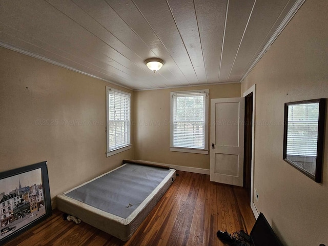 unfurnished bedroom featuring crown molding and dark hardwood / wood-style flooring