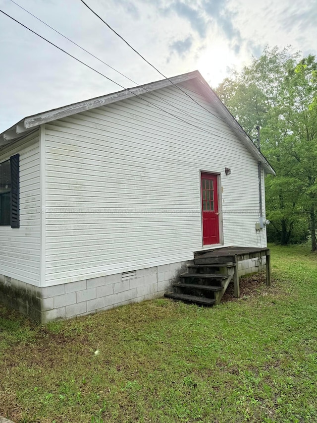 view of side of home with a lawn and crawl space