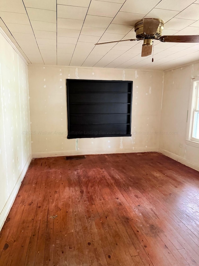 unfurnished room featuring hardwood / wood-style flooring, baseboards, and a ceiling fan