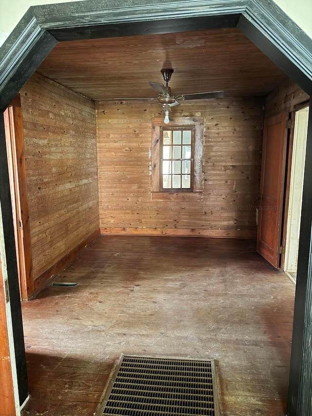 interior space with hardwood / wood-style floors, visible vents, and wood walls