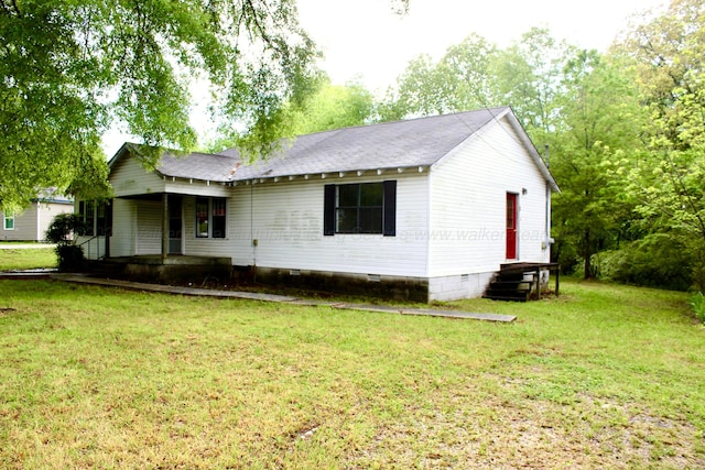 ranch-style house featuring crawl space, a porch, roof with shingles, and a front yard