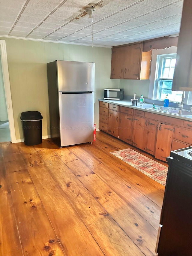 1670 County Highway 47, Winfield, AL 35594 - kitchen featuring light countertops, light wood-type flooring, stainless steel appliances, a sink, and brown cabinets