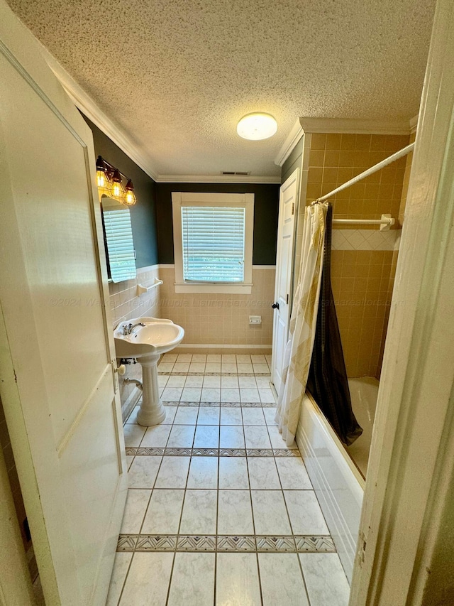 full bath featuring shower / bathtub combination with curtain, a textured ceiling, wainscoting, tile patterned flooring, and ornamental molding
