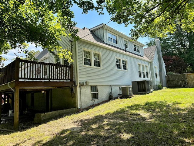 back of house featuring central air condition unit, a wooden deck, fence, and a yard