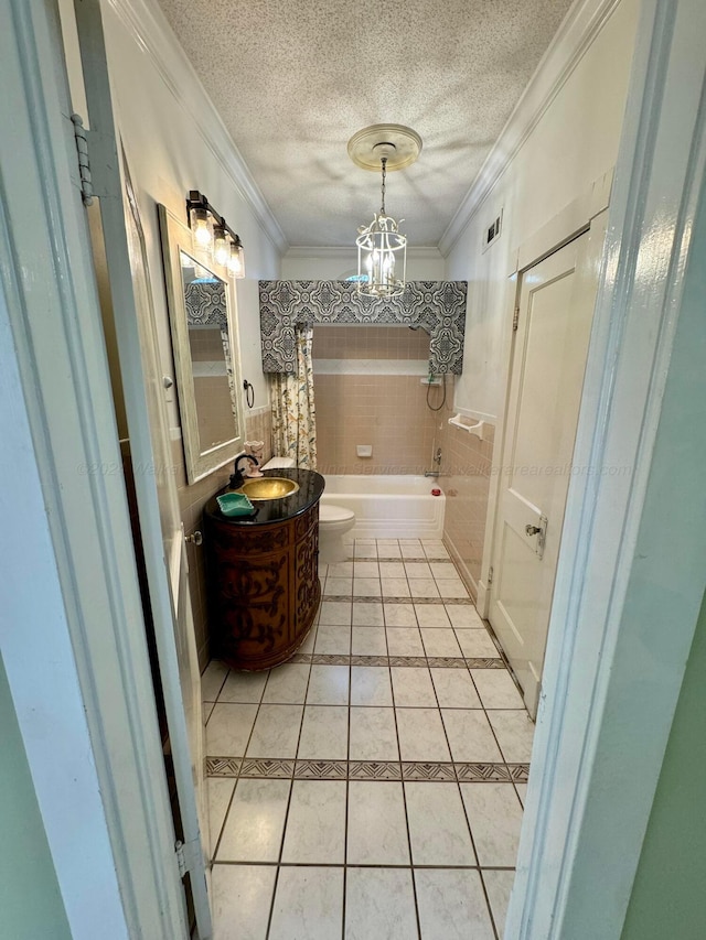 bathroom featuring tile patterned floors, toilet, a textured ceiling, a bath, and ornamental molding