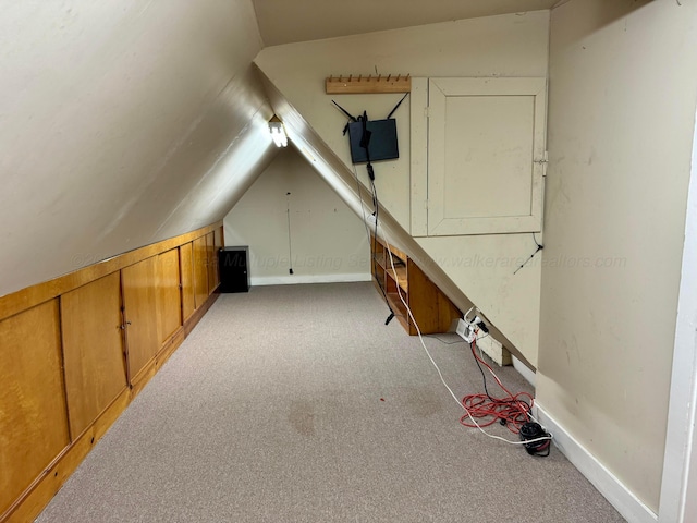 bonus room with carpet floors, baseboards, and vaulted ceiling