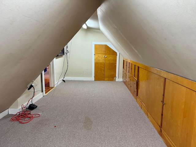 bonus room featuring vaulted ceiling and carpet
