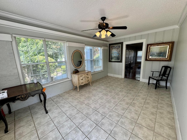 living area with a textured ceiling, a ceiling fan, light tile patterned flooring, and crown molding