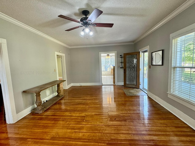 interior space with a ceiling fan, ornamental molding, a textured ceiling, and wood finished floors