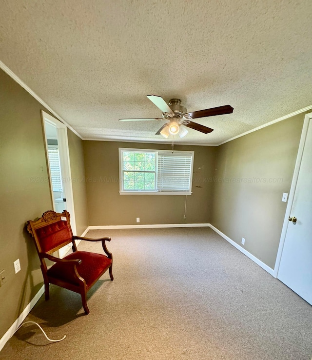 living area featuring baseboards, carpet flooring, ornamental molding, and ceiling fan