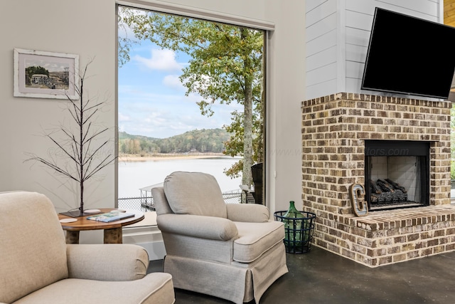 living area featuring a water view and a fireplace