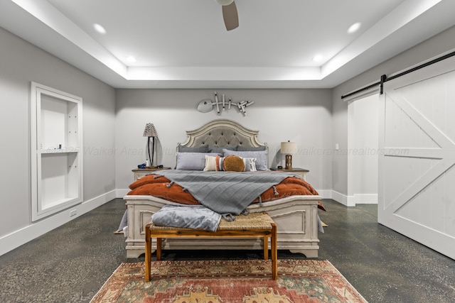 bedroom with a raised ceiling, a barn door, and ceiling fan