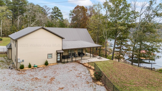 view of side of home with a patio and a lawn