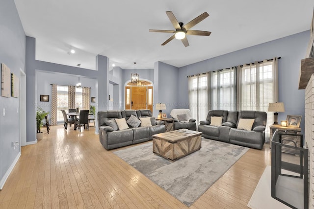 living room featuring light wood finished floors, baseboards, and a wealth of natural light