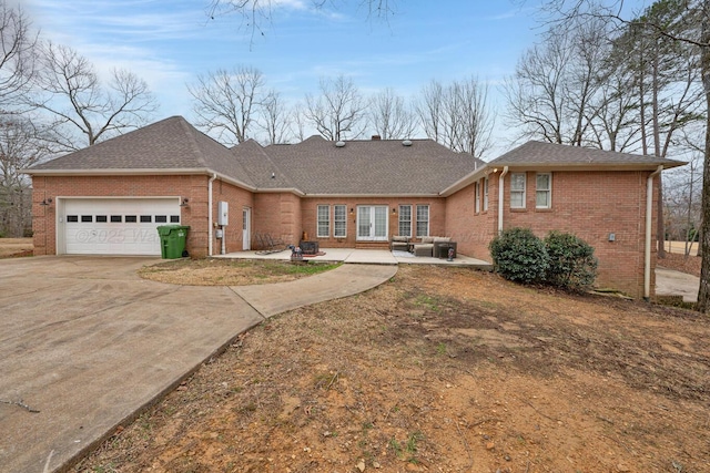 single story home with a patio, concrete driveway, a shingled roof, a garage, and brick siding