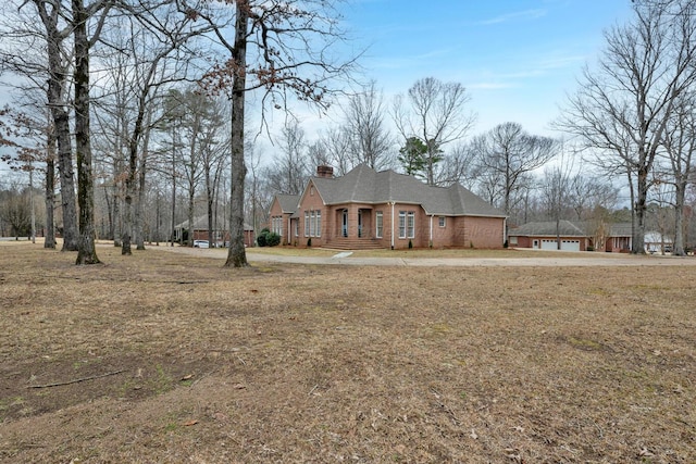 view of front of property featuring brick siding and a chimney