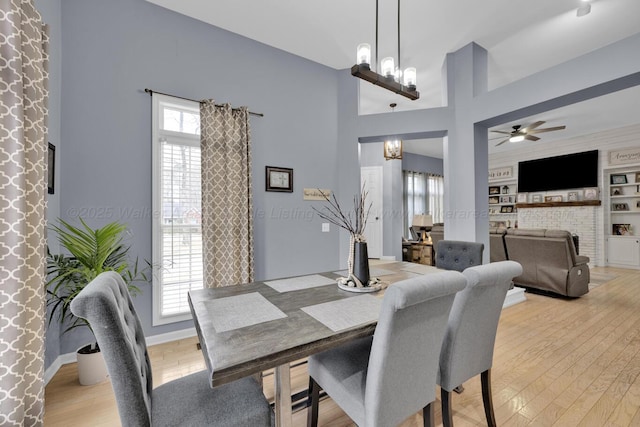 dining area with a wealth of natural light, built in shelves, and light wood-type flooring