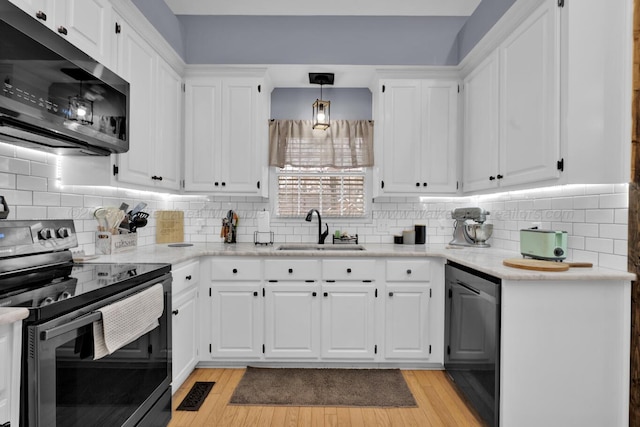 kitchen with dishwasher, electric range, white cabinets, and a sink