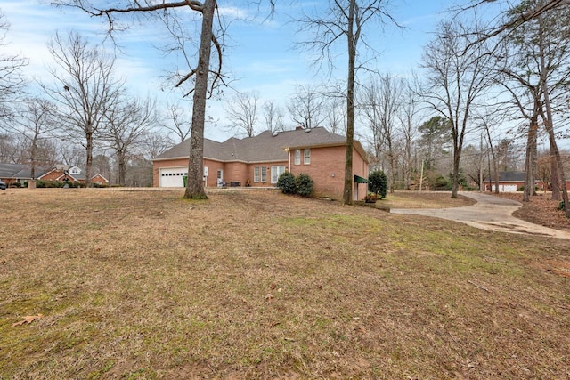 single story home featuring a garage, brick siding, and a front yard