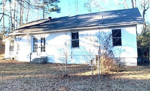 view of side of home featuring entry steps and french doors