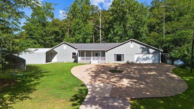 view of front of home with a front lawn, a porch, a garage, and a carport