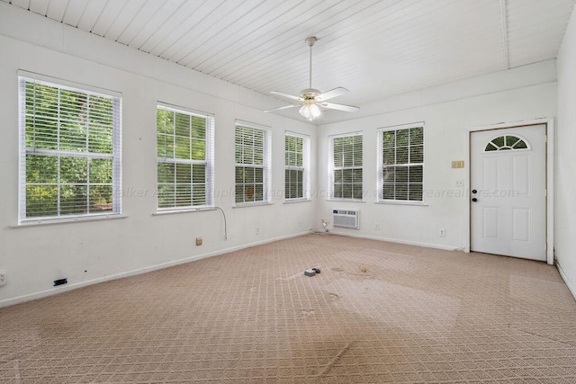 unfurnished sunroom featuring an AC wall unit and ceiling fan