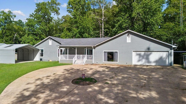 back of property featuring a lawn, covered porch, a garage, and a carport