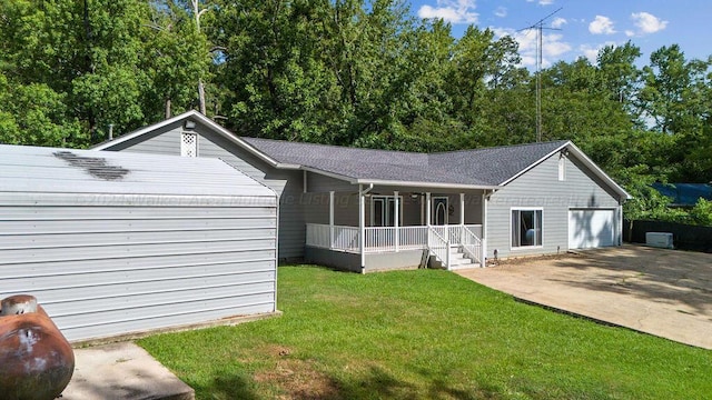 back of house with covered porch and a yard